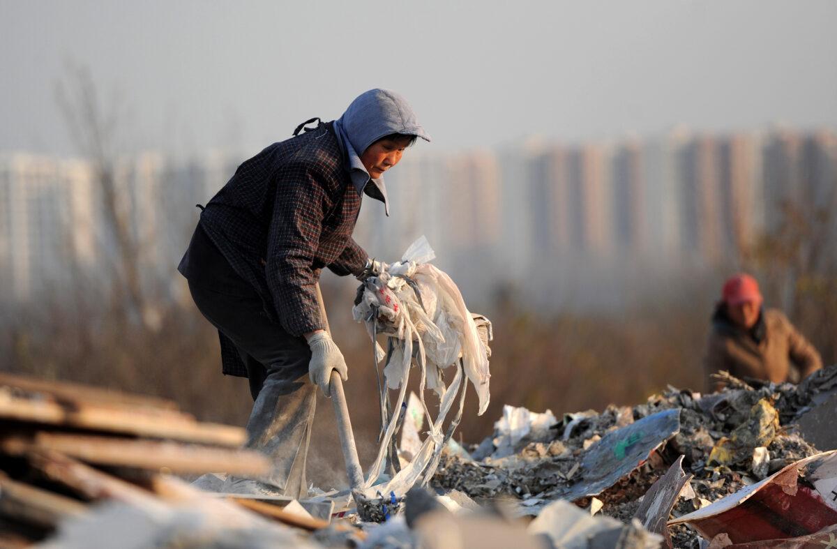 Scavengers pick up useful construction waste from a garbage dump in Hefei, central China's Anhui Province, on Dec. 9, 2012. China's wealth gap has widened to a level where it is among the world's most unequal nations, a Chinese academic institute said in a survey, as huge numbers of poor are left behind by the economic boom. (STR/AFP via Getty Images)