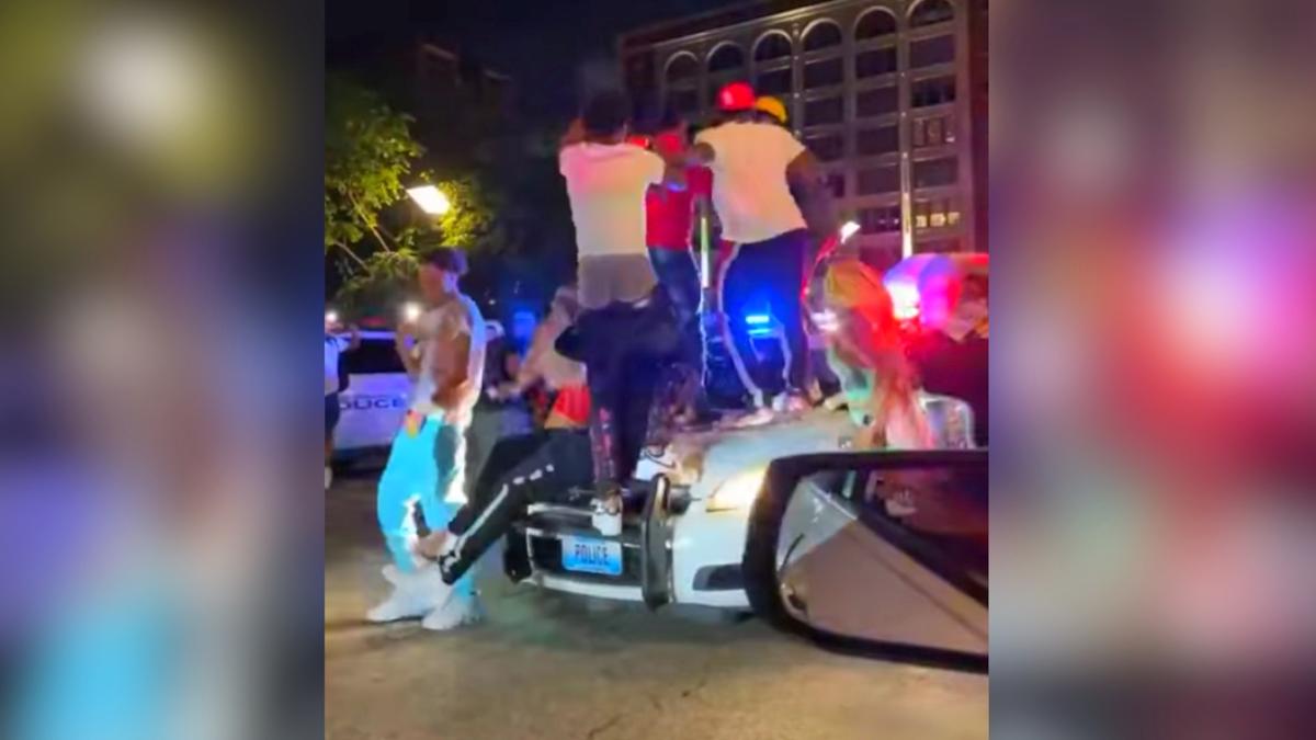 A crowd of party-goers in St. Louis, Missouri, are seen jumping and stomping on top of an officer's patrol vehicle on May 23, 2021. (Courtesy of St. Louis Metropolitan Police Department)