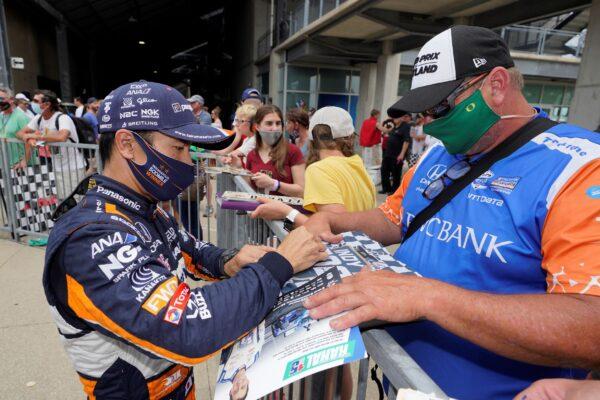 Takuma Sato, of Japan, signs an autograph for a fan during qualifications for the Indianapolis 500 auto race at Indianapolis Motor Speedway, in Indianapolis, Ind., on May 22, 2021. (Darron Cummings/AP Photo)
