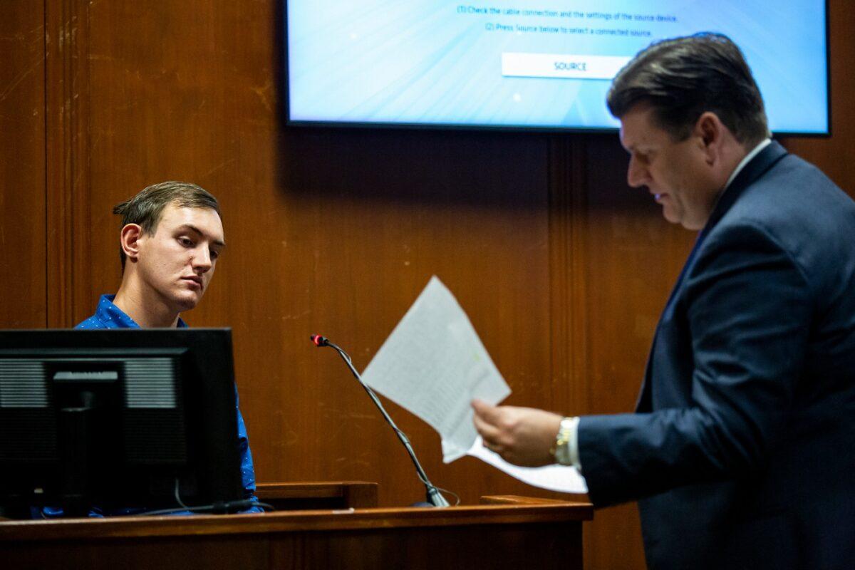 Defense attorney Chad Frese (R) hands Dalton Jack, Mollie Tibbetts's boyfriend, a phone record to review as Jack testifies for a second time during Cristhian Bahena Rivera's trial, in the Scott County Courthouse in Davenport, Iowa, on May 25, 2021. (Kelsey Kremer/Pool/The Des Moines Register via AP)