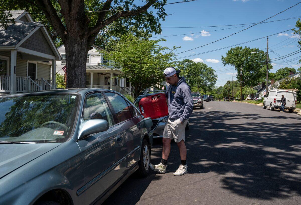 A man fills his car with gas that his mother drove down from Maryland after he ran out of gas and couldn't find any in the Arlington, Va., area on May 13, 2021. (Andrew Caballero-Reynolds/AFP via Getty Images)