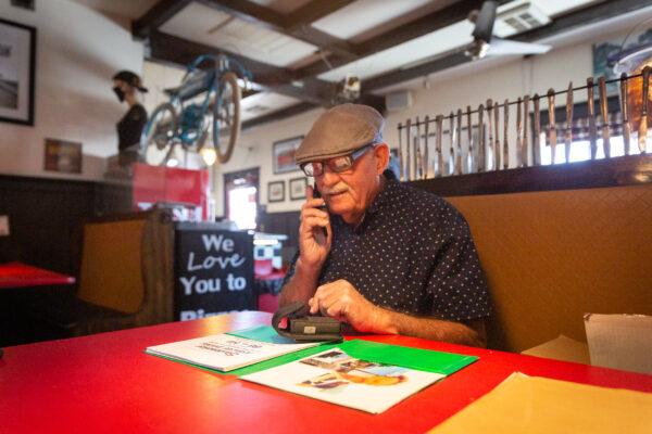 Joe Manners makes a phone call in the Cross Eyed Cow Pizza restaurant in Oro Grande, Calif., on May 18, 2021. (John Fredricks/The Epoch Times)
