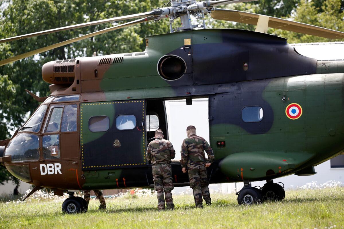 French soldiers stand near a French Army helicopter after an assailant stabbed and badly wounded a policewoman in La Chapelle-sur-Erdre, western France, on May 28, 2021. (Stephane Mahe/Reuters)