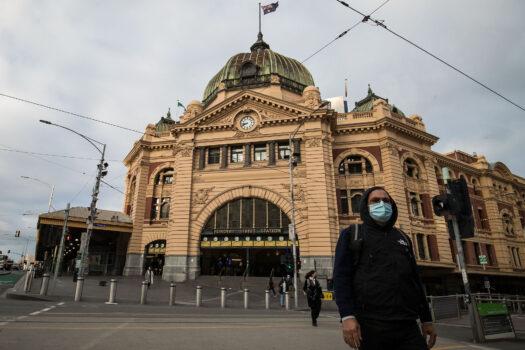 A man crosses the normally busy intersection of Flinders Street and Swanston Street in Melbourne, Australia, on May 28, 2021. (Darrian Traynor/Getty Images)