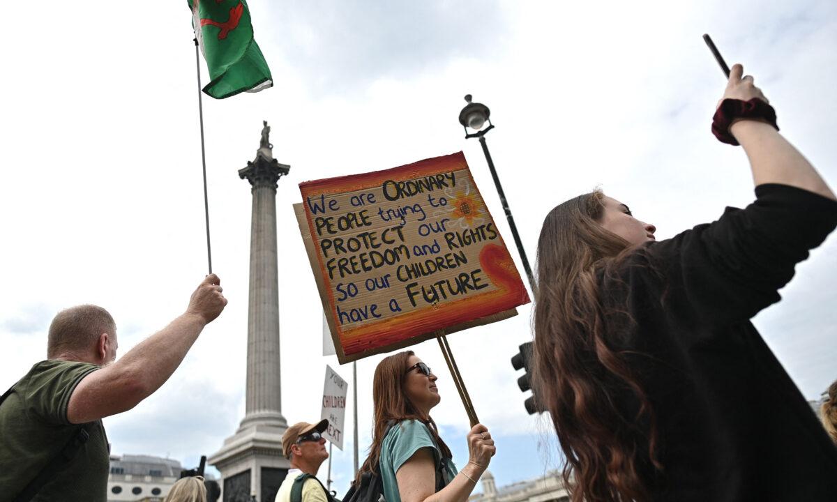 Protesters carry placards during a 'Unite For Freedom' rally against CCP virus vaccine passport and government lockdown restrictions, in Trafalgar Square, central London on May 29, 2021. (Ben Stansall/AFP via Getty Images)