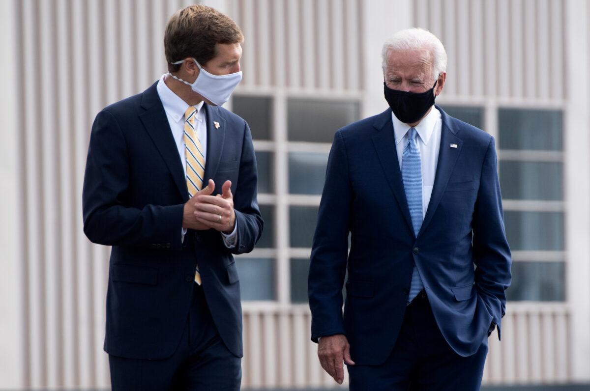 Then Democratic presidential nominee Joe Biden (R) speaks with U.S. Rep. Conor Lamb (D-Pa.) as he walks to board an airplane at Allegheny County Airport in West Mifflin, Pa., on Aug. 31, 2020. (Saul Loeb/AFP via Getty Images)