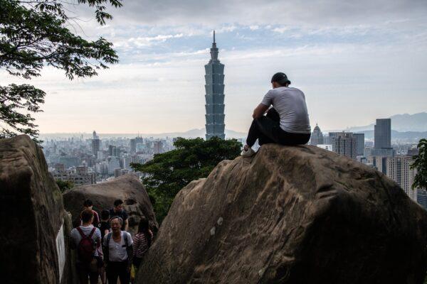 A man sits on a rock overlooking the Taipei 101 tower and the Taipei skyline on the top of Elephant Mountain on Jan. 7, 2020, in Taipei, Taiwan. (Carl Court/Getty Images)