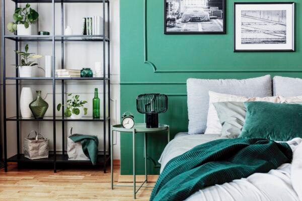 The contrasting colors are reinforced by the wall trim, highlighting two distinct areas within one room. The sleeping area and the objects on the shelving unit—in white and green tones—create a sense of harmony. (Katarzyna Bialasiewicz/Dreamstime.com)