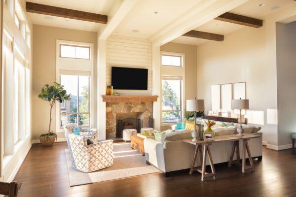 The tall vertical windows and horizontal ceiling beams give a sense of the room's scale. It is balanced with the furniture placement, fireplace mantel, lamps on the table, and vertical pictures on the right wall. Also, take note of how the rug encapsulates the seating area. (Breadmaker/Dreamstime.com)