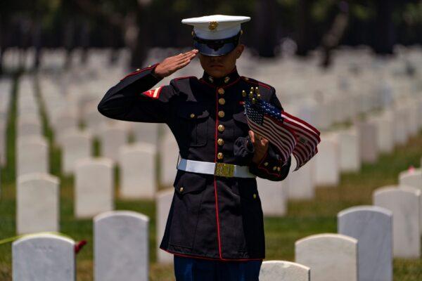 A U.S. Marine Corps salutes veterans at the Los Angeles National Cemetery in Los Angeles, Calif., on May 31, 2021. (Damian Dovarganes/AP Photo)