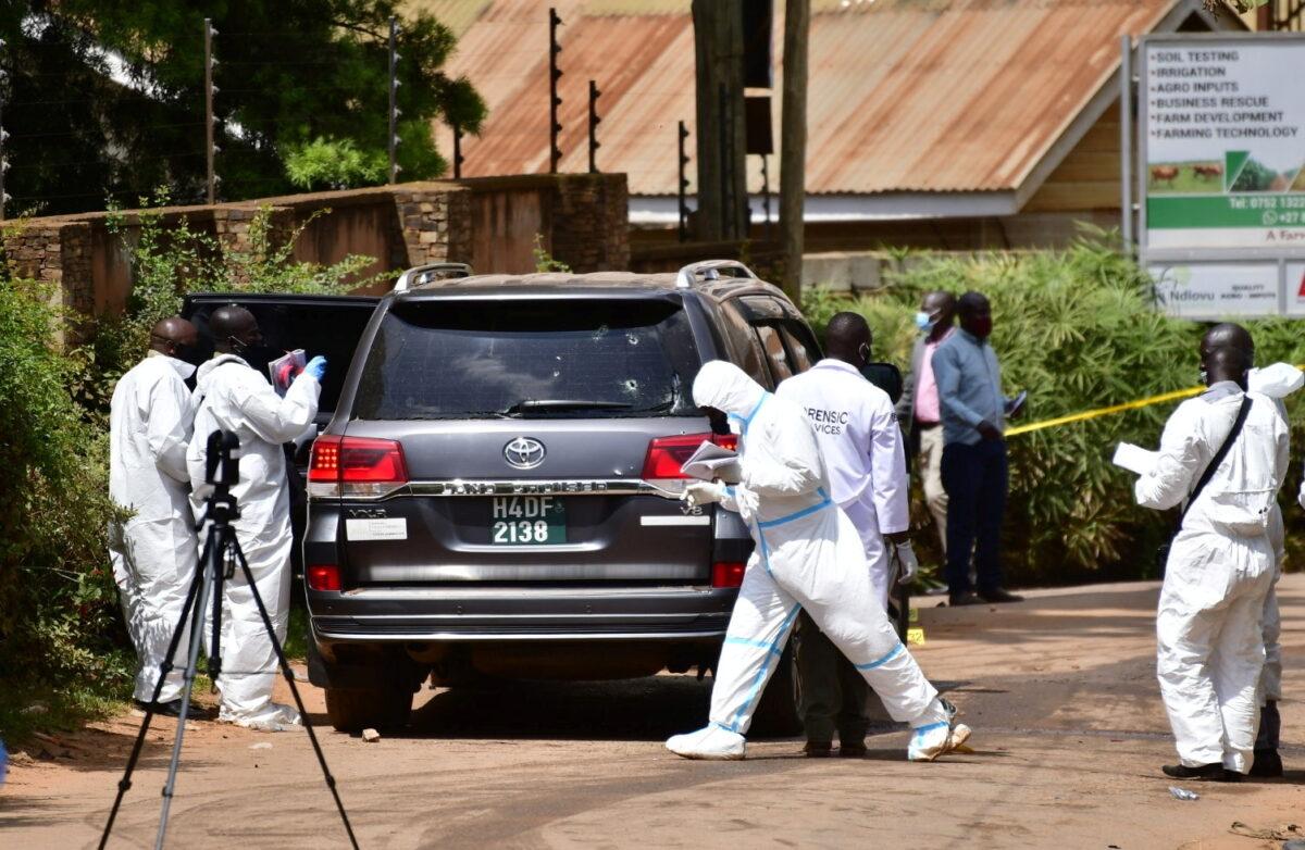 Forensic experts secure the scene of an attempted assassination on Ugandan minister of works and transport General Katumba Wamala in the suburb of Kiasasi within Kampala, Uganda, on June 1, 2021. (Abubaker Lubowa/Reuters)