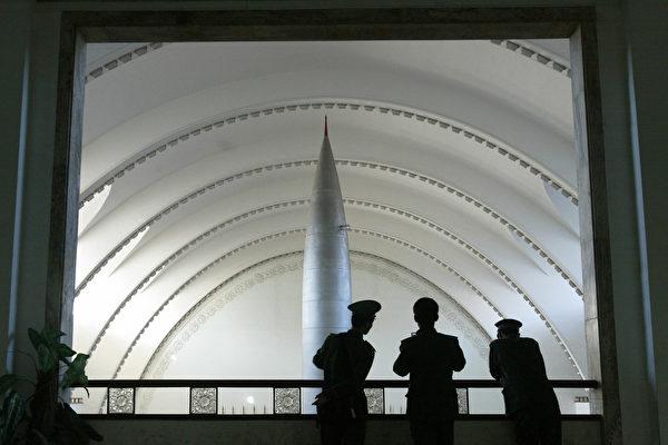 Chinese People's Liberation Army soldiers take in the view from a balcony at the Military Museum in Beijing of a Chinese-made Dongfang-1 missile on display on the main floor on Dec. 6, 2004. (Frederic J. Brown/AFP via Getty Images)