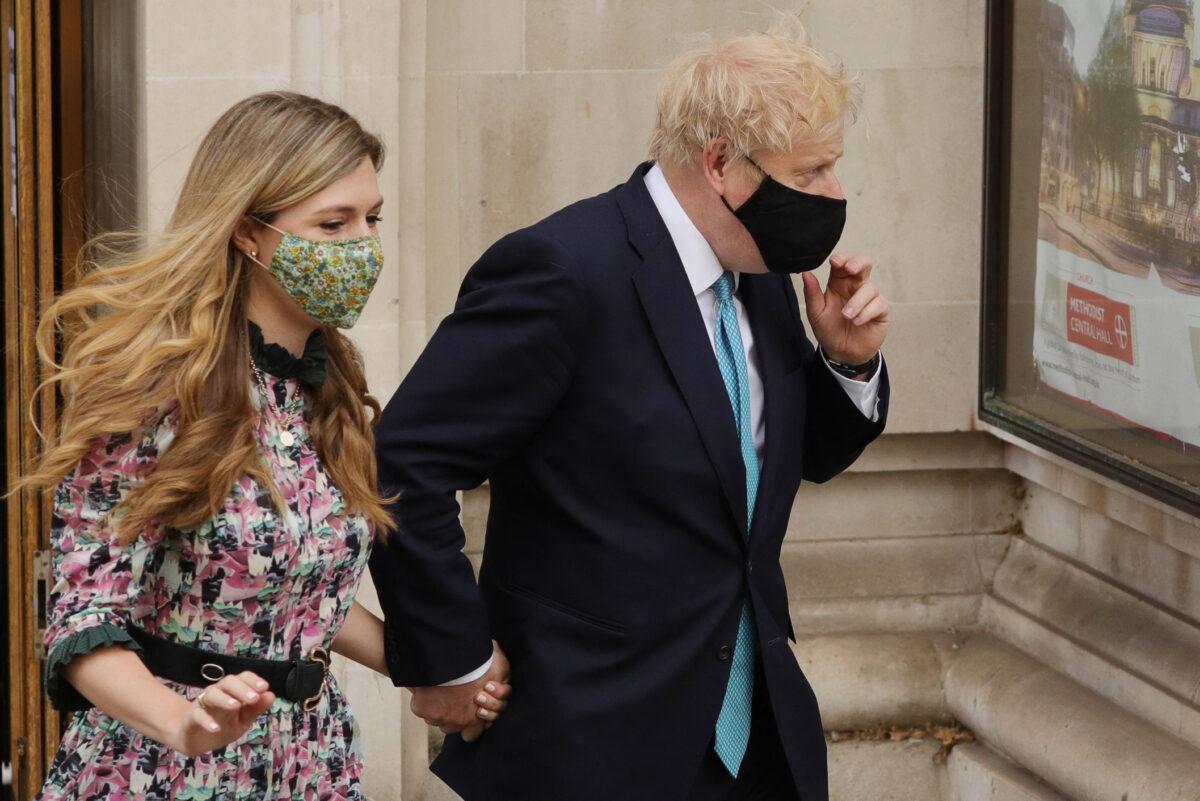 Britain's Prime Minister Boris Johnson and partner Carrie Symonds leave Methodist Hall after casting their votes in local elections in central London, on May 6, 2021. (AFP via Getty Images)