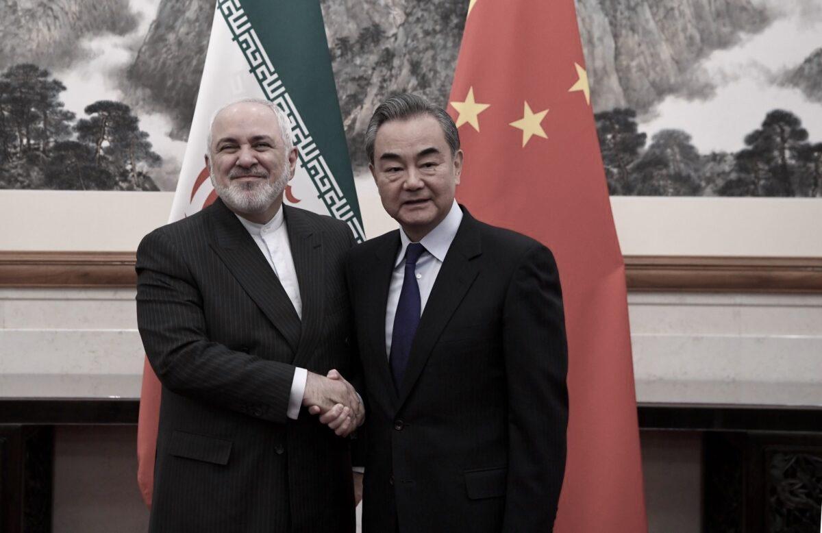 China's Foreign Minister Wang Yi shakes hands with Iran's Foreign Minister Mohammad Javad Zarif during a meeting at the Diaoyutai state guest house in Beijing, China, on Dec. 31, 2019. (Noel Celis-Pool/Getty Images)