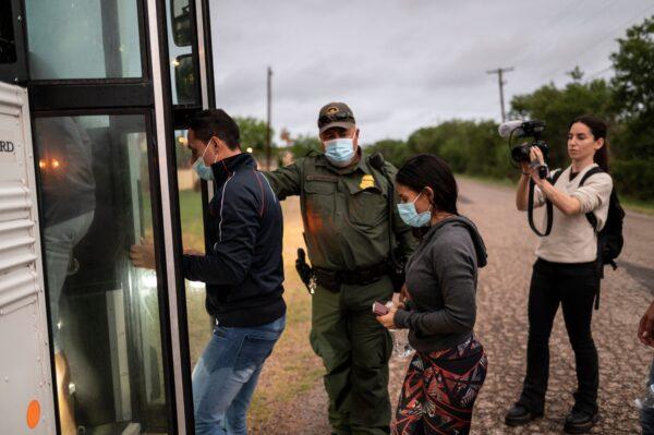 Illegal migrants board a bus after being apprehended near the border between Mexico and the United States in Del Rio, Texas, on May 16, 2021. (Sergio Flores/AFP via Getty Images)