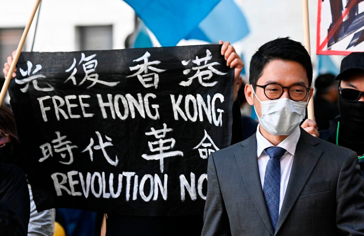 Hong Kong democracy activist Nathan Law stands next to a banner reading "Free Hong Kong. Revolution now" as he attends a demonstration outside the Foreign Office in Berlin, Germany, on Sept. 1, 2020. (Tobias Schwarz/AFP via Getty Images)