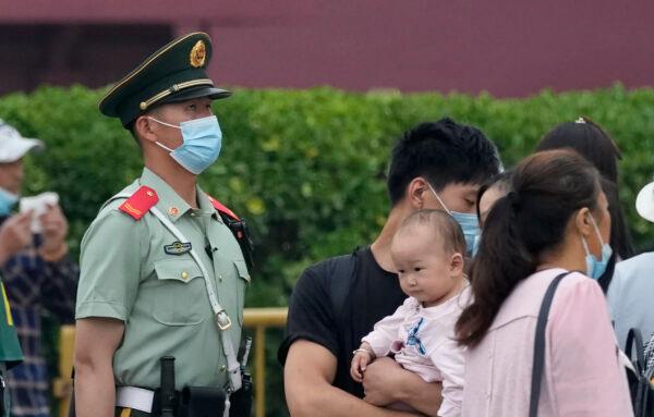 A paramilitary police officer stands guard as visitors pass near the Tiananmen Gate in Beijing, China, on June 2, 2021. (Ng Han Guan/AP Photo)