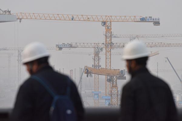 Workers stand outside construction site of the new Beijing Daxing International Airport, in Beijing, on March 1, 2019. (Greg Baker/AFP/Getty Images)