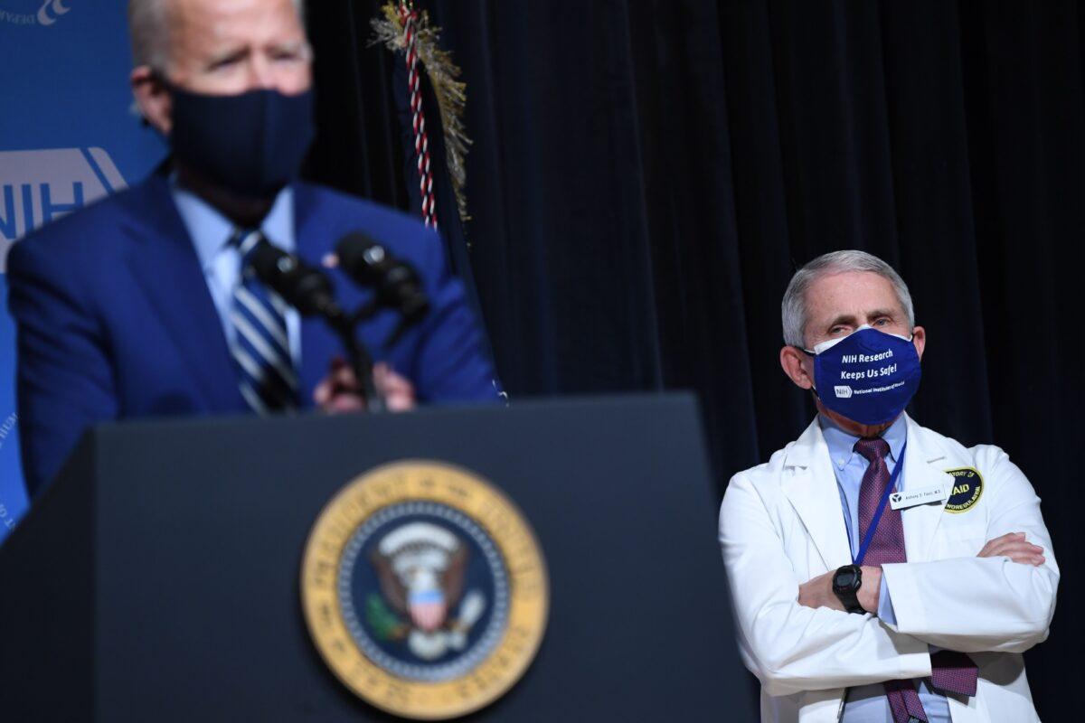 President Joe Biden speaks, flanked by White House Chief Medical Adviser on COVID-19 Dr. Anthony Fauci, during a visit to the National Institutes of Health (NIH) in Bethesda, Md., on Feb. 11, 2021. (Saul Loeb/AFP via Getty Images)