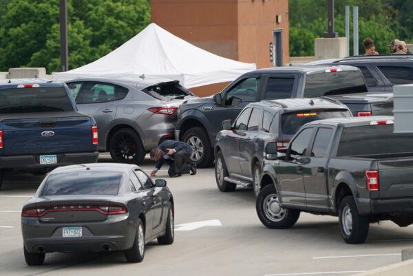 An investigator goes through the scene of a crash believed to be part of an officer involved shooting on the top of a parking ramp in Minneapolis, Minn., on June 3, 2021. (Renee Jones Schneider/Star Tribune via AP)