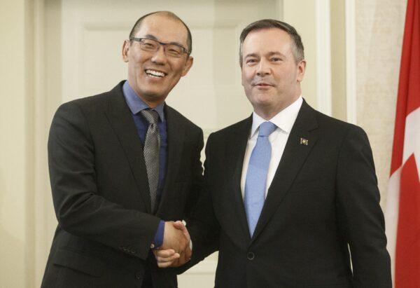 Alberta Premier Jason Kenney shakes hands with Jason Luan (L), associate minister of mental health and addictions, after being sworn into office in Edmonton on April 30, 2019. (Jason Franson/The Canadian Press)