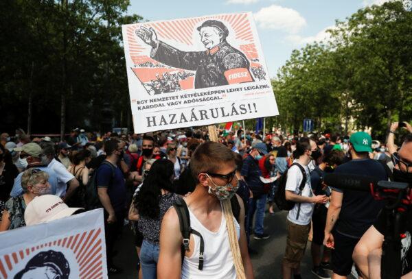 A demonstrator holds a placard reading "Treason" during a protest against the planned Chinese Fudan University campus in Budapest, Hungary, June 5, 2021. (Bernadett Szabo/Reuters)