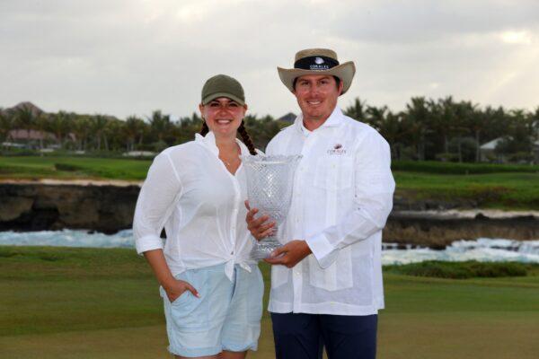 Joel Dahmen poses with the trophy and his wife Lona after putting in to win on the 18th green during the final round of the Corales Puntacana Resort & Club Championship in Punta Cana, Dominican Republic, on March 28, 2021. (Kevin C. Cox/Getty Images)