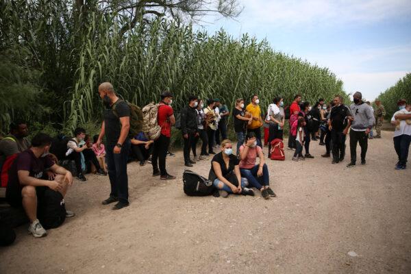 A group of Venezuelans waits to be picked up by Border Patrol after illegally crossing the Rio Grande from Mexico into Del Rio, Texas, on June 3, 2021. (Charlotte Cuthbertson/The Epoch Times)