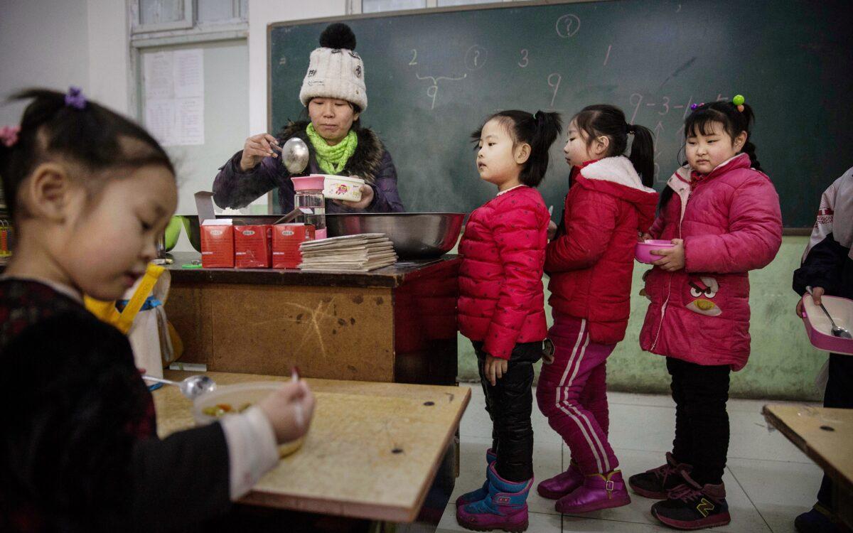 Chinese students wait in line for lunch in a classroom at an unofficial school in Beijing on Dec. 18, 2015. (Kevin Frayer/Getty Images)