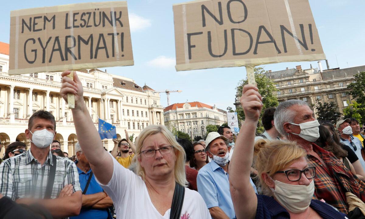 Protesters hold placards reading in Hungarian "we will not be a colony" (L), and "No Fudan" as they gather in downtown Budapest, Hungary, on June 5, 2021. (Laszlo Balogh/AP Photo)