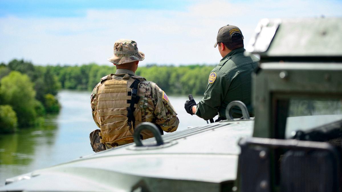 A Texas National Guardsman and a U.S. Customs and Border Patrol agent discuss the lay of the land on the shores of the Rio Grande River in Starr County, Texas, on April 10, 2018. (Army Sgt. Mark Otte/Defense Department)