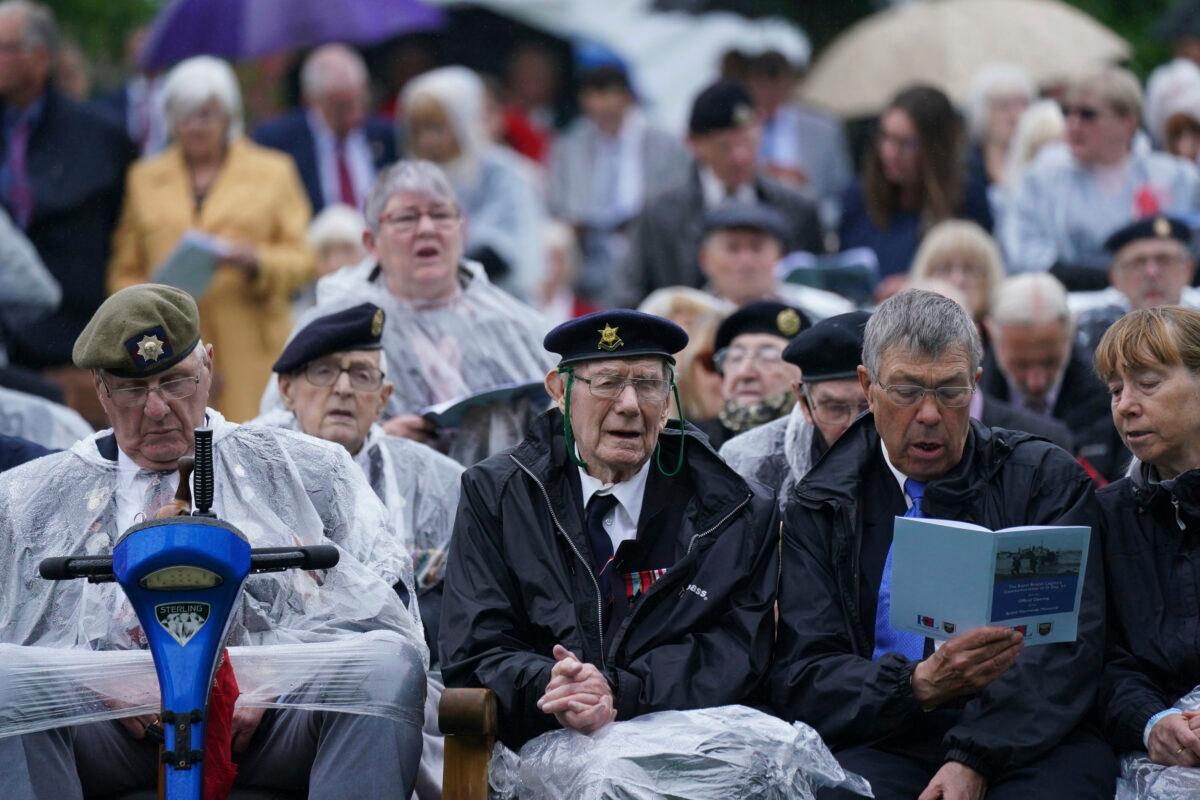 Veterans sing as they watch the official opening of the British Normandy Memorial in France via a live feed, during a ceremony at the National Memorial Arboretum in Alrewas, England, on June 6, 2021. (Jacob King/PA via AP)