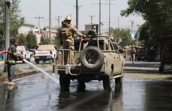 Afghan security personnel leave the scene of a roadside bomb explosion in Kabul, Afghanistan, on June 6, 2021. (Rahmat Gul/AP Photo)