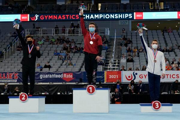 (L-R) Yul Moldauer, Brody Malone, and Sam Mikulak stand on their respective podiums after finishing in the top three positions during the U.S. Gymnastics Championships, in Fort Worth, Texas, on June 5, 2021. (Tony Gutierrez/AP Photo)