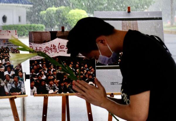 A man lays flowers to commemorate the victims of the 1989 Tiananmen Square crackdown in Beijing, during a vigil in front of Liberty Square in Taipei, Taiwan, on June 4, 2021. (SAM YEH/AFP via Getty Images)