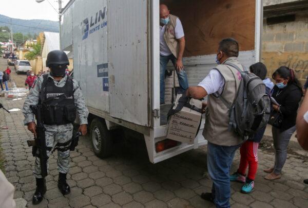 Members of the National Guard look on as vehicles arrive carrying voting booths and electoral boxes ahead of midterm elections in Nahuatzen, Mexico, on June 5, 2021. (Alan Ortega/Reuters)