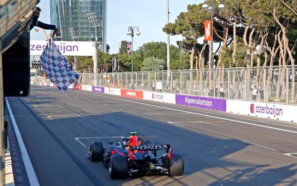 The checkered flag waves for Red Bull driver Sergio Perez of Mexico as he crosses the finish line to win the Formula One Grand Prix at the Baku Formula One city circuit in Baku, Azerbaijan, on June 6, 2021. (Maxim Shemetov/Pool via AP)