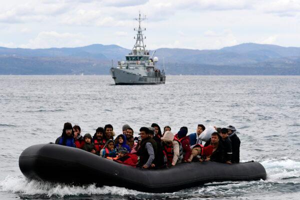 Refugees and migrants arrive in a dinghy accompanied by Frontex vessels at the village of Skala Sikaminias, on the Greek island of Lesbos, after crossing the Aegean sea from Turkey, on Feb. 28, 2020. (Michael Varaklas/AP Photo)