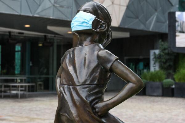 The Fearless Girl Statue in Federation square is seen with a mask on June 5, 2021, in Melbourne, Australia. (Asanka Ratnayake/Getty Images)