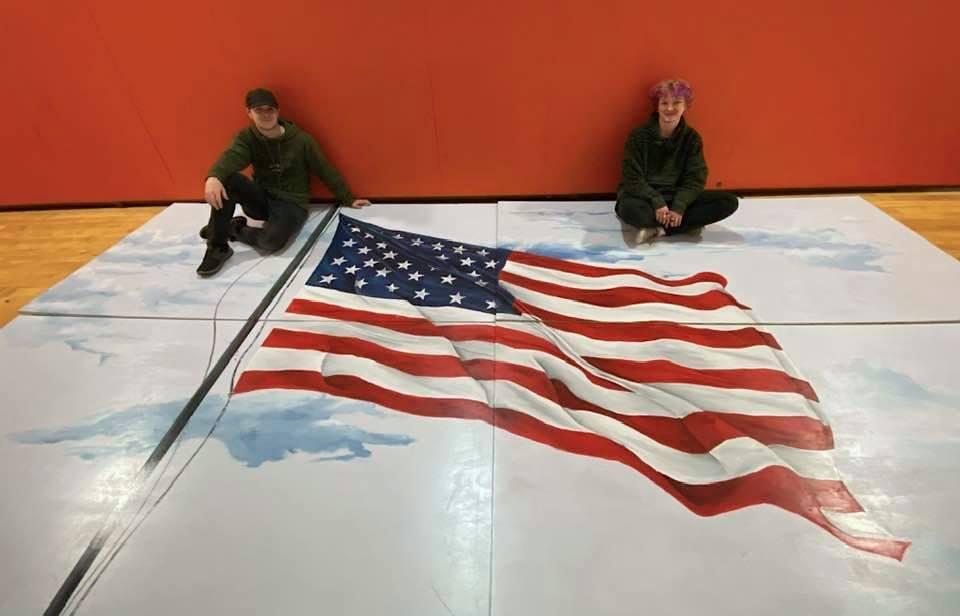 The artist (L) posing with his finished American flag mural. (Courtesy of <a href="https://www.facebook.com/BrendaRaub">Brenda Raub</a>)