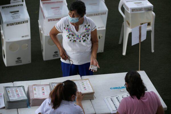 A woman shows her ID before voting in Acapulco, Mexico, on June 6, 2021. (Fernando Llano/AP Photo)