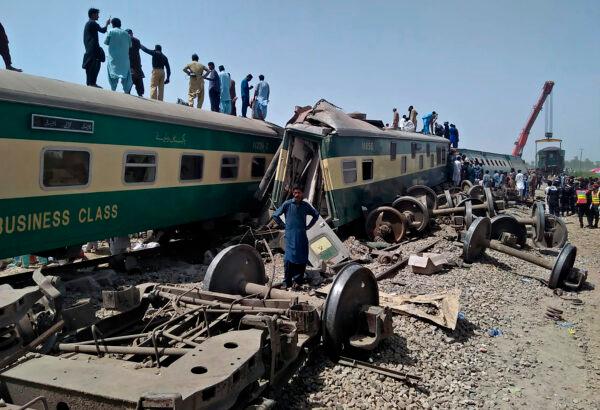 Pakistani volunteers and troops work at the site of trains collided in Ghotki district in the southern Pakistan, on June 7, 2021. (Waleed Saddique/AP Photo)