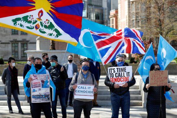 Demonstrators hold placards during a protest against Uyghur genocide, in London, on April 22, 2021. (Peter Nicholl//Reuters)