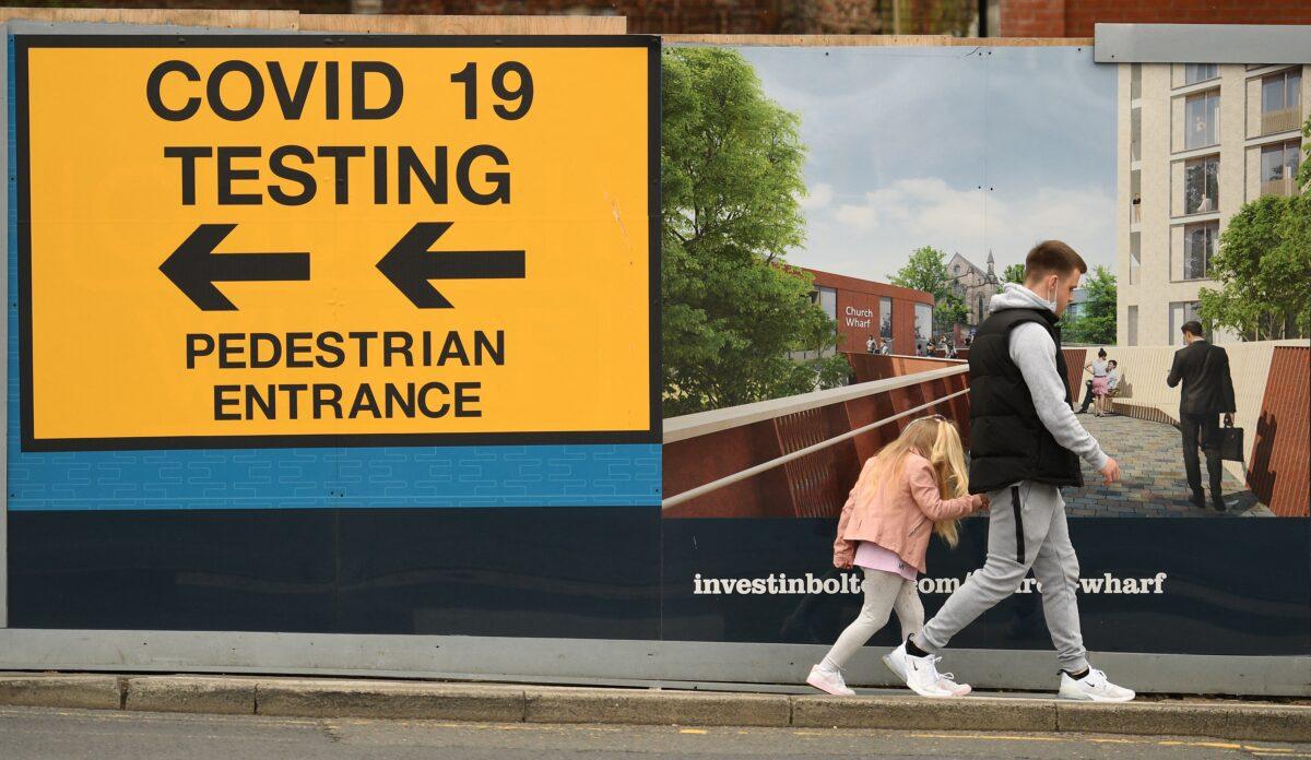 A pedestrian walks past a sign directing members of the public to a COVID-19 testing centre in Bolton, northwest England, on May 28, 2021. (Oli Scarff/AFP via Getty Images)