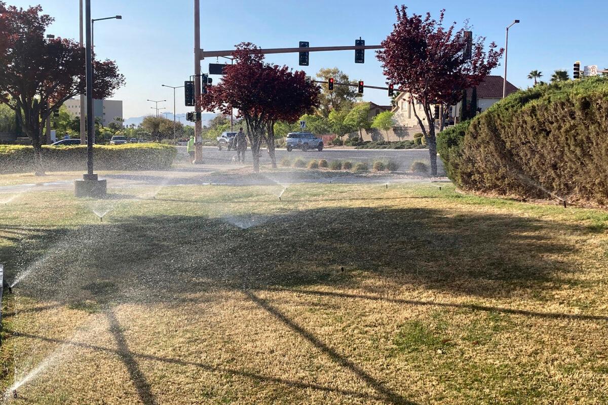 Sprinklers water grass near a street corner in Las Vegas, Nev., on April 9, 2021. (Ken Ritter, File/AP Photo)