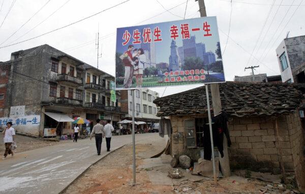 A Chinese "one-child" policy billboard saying, "Have fewer children, have a better life" greets residents on the main street of Shuangwang, in southern China's Guangxi region, 25 May 2007. Residents of this riot-hit area of southern China demanded 25 May 2007 that authorities make amends for a brutal three-month campaign to enforce family-planning rules as tension remained high, nearly a week after thousands clashed with police over an official campaign that residents say included forced abortions, property destruction, and arrests aimed at violators of the "one-child policy." (Goh Chai Hin/AFP via Getty Images)