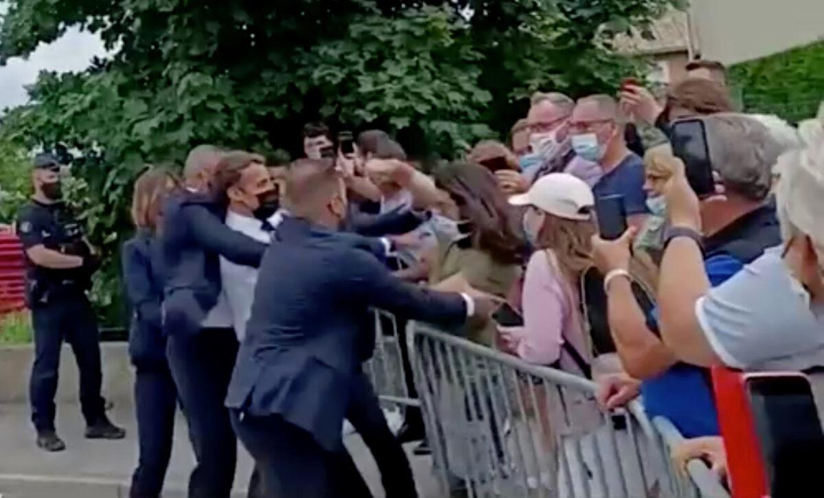 French President Emmanuel Macron is slapped in the face by a member of the public during a visit to Tain-l'Hermitage, France, on June 8, 2021. (BFMTV via Reuters TV)