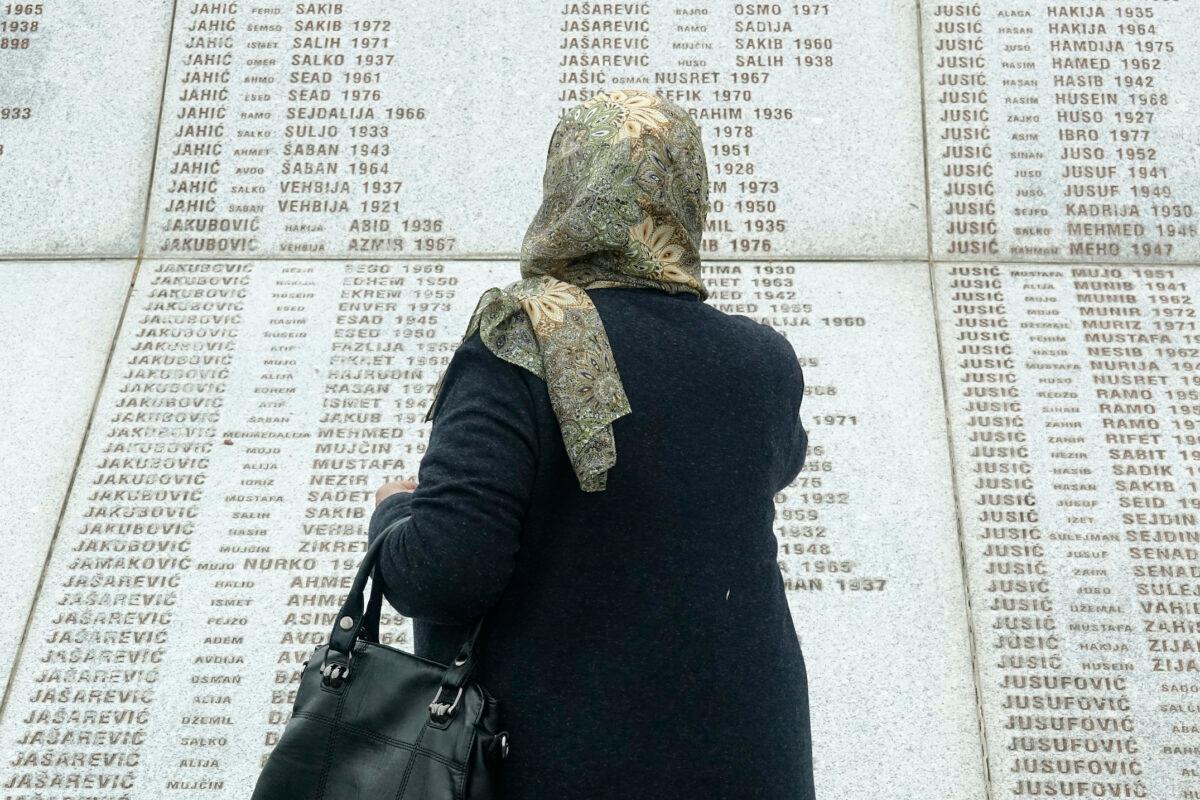 Djulija Jusic who lost her two sons and 33 relatives in the Srebrenica massacre, looks at names at the memorial cemetery in Potocari near Srebrenica, Bosnia, Friday, May 28, 2021. (Eldar Emric/AP Photo)