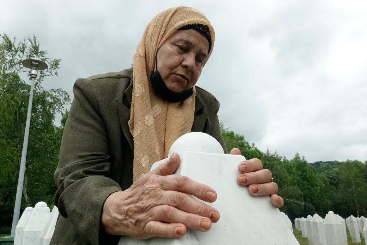 Bida Osmanovic, who lost her son and her mother in the Srebrenica massacre, prays at the memorial cemetery in Potocari near Srebrenica, Bosnia, Friday, May 28, 2021. (Eldar Emric/AP Photo)