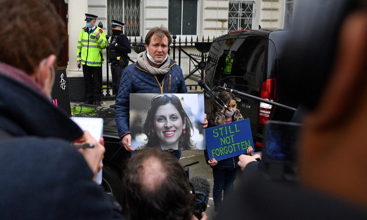 Richard Ratcliffe, husband of British-Iranian aid worker Nazanin Zaghari-Ratcliffe jailed in Tehran since 2016, and his daughter Gabriella, attend a protest outside of the Iranian Embassy in London on March 8, 2021. (Ben Stansall/AFP via Getty Images)